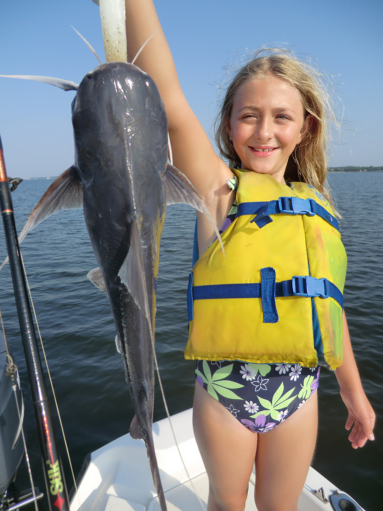 girl catching fish on charter